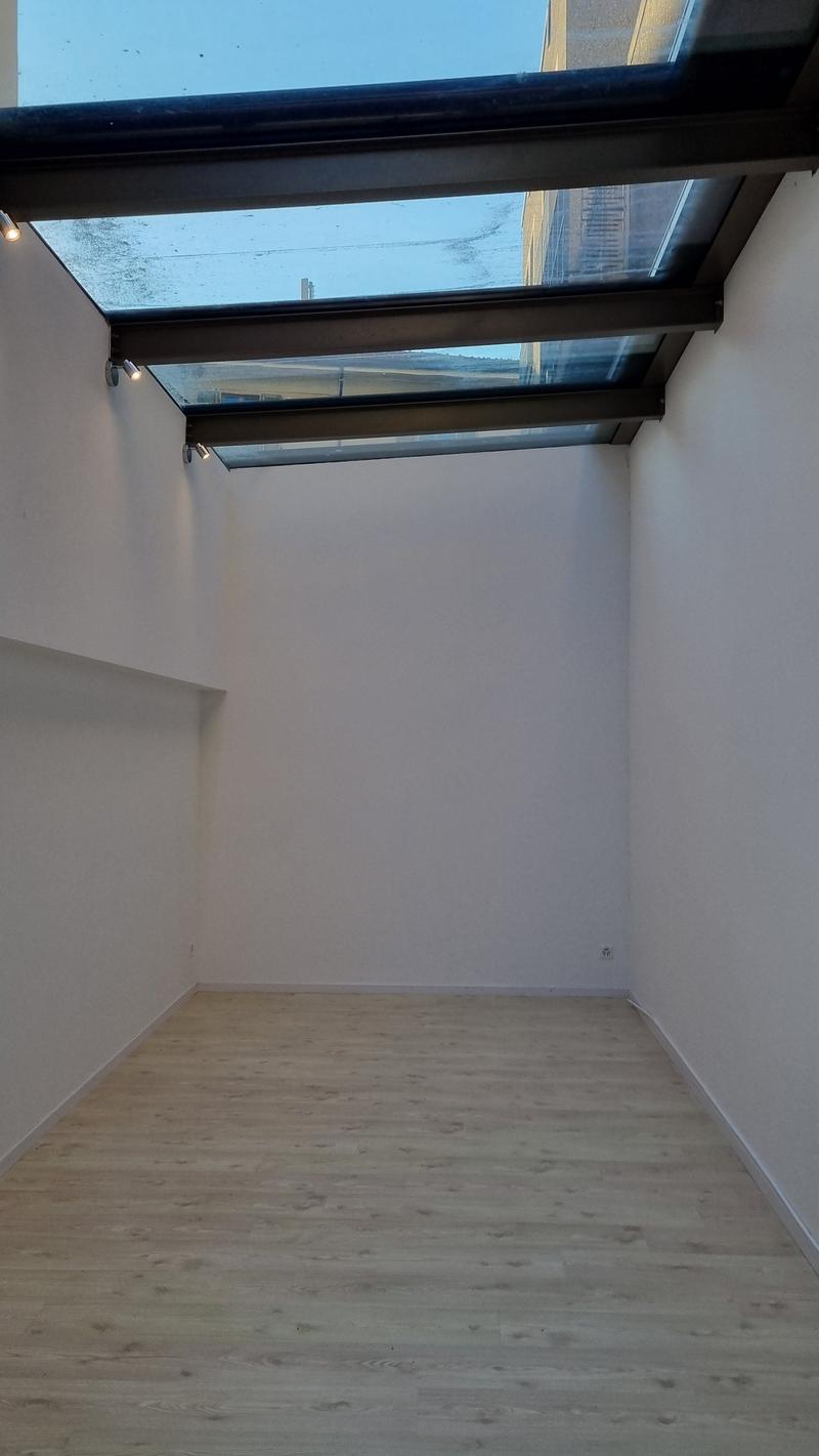 empty room, wooden floor, white walls, glass ceiling, wall mounted lights