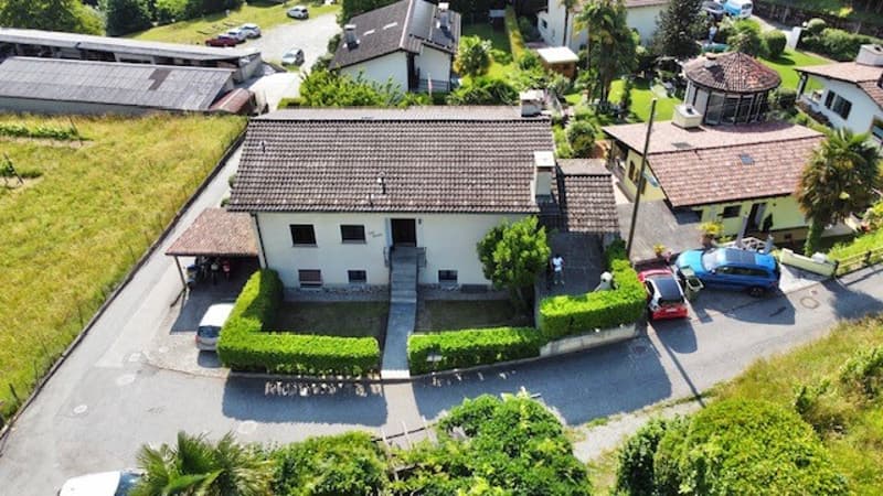 House: white with brown roof, two floors, attached garage, four cars parked in front, driveway