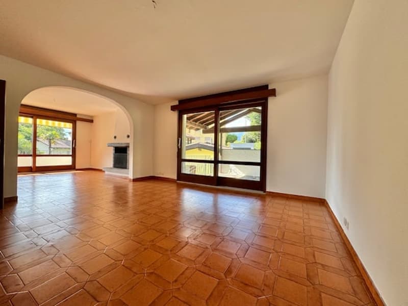 empty room, wooden flooring, sliding glass doors, arched entry, fireplace