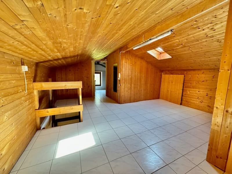 White tiled floor, wooden walls, wooden bunk beds, skylight window, interior door, white light