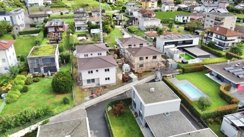 multiple houses, brown roofs, swimming pool, garden, driveway, green field, trees