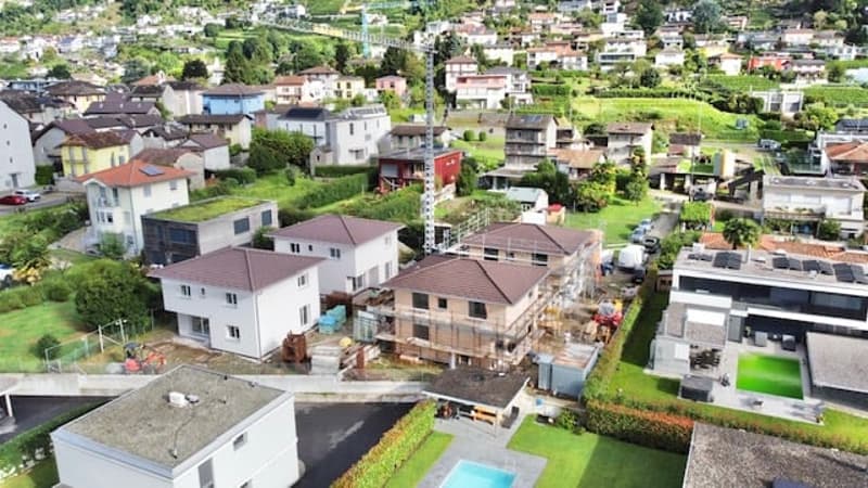 Aerial view of a new construction of houses and townhouses, one of which is under construction