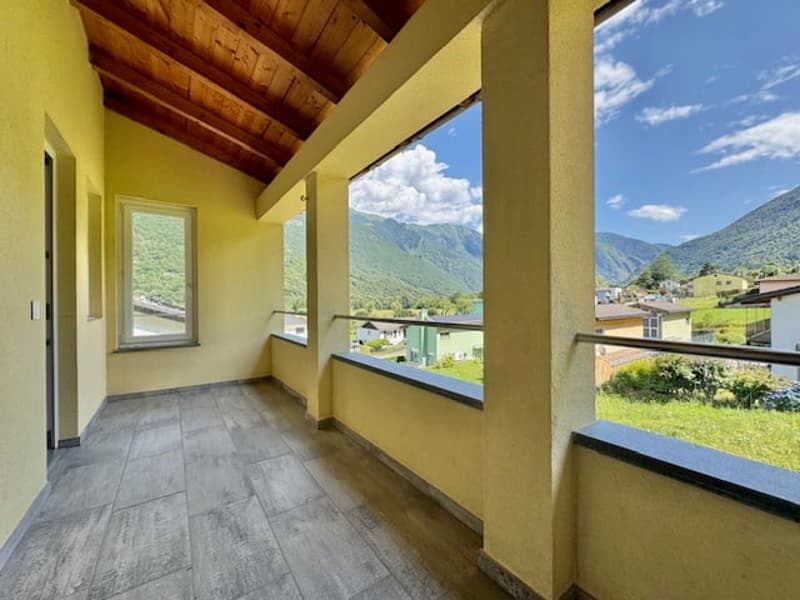 Spacious room with wooden ceiling, large windows providing a scenic mountain view, and a balcony or terrace area.