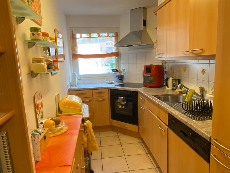 small kitchen with counter, window, built-in oven, red air fryer, coffee machine, tiled flooring