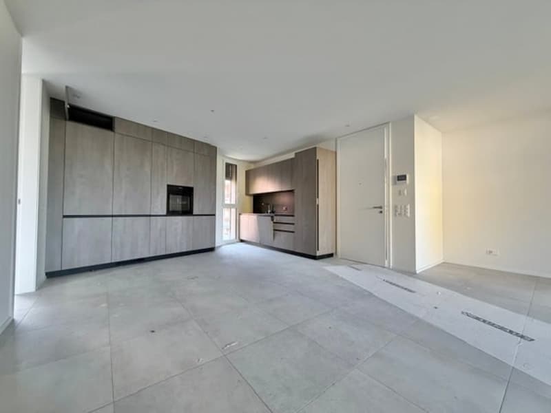 Empty room with tiled floor, built-in cabinets, and a white door.