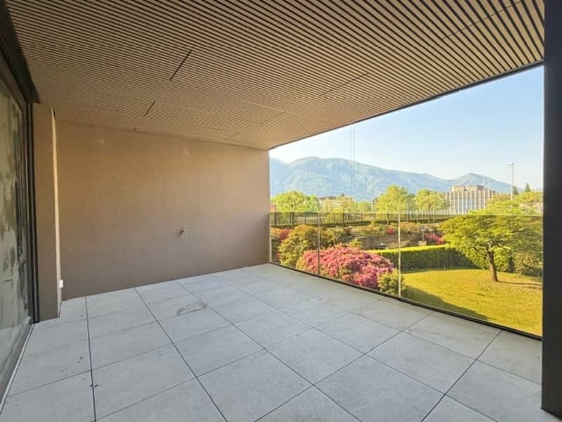 Balcony with tiled floor, glass railing, view of mountains and greenery