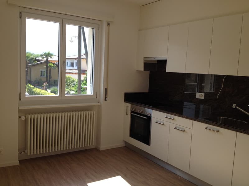 white cabinetry, tiled flooring, modern appliances, glass window