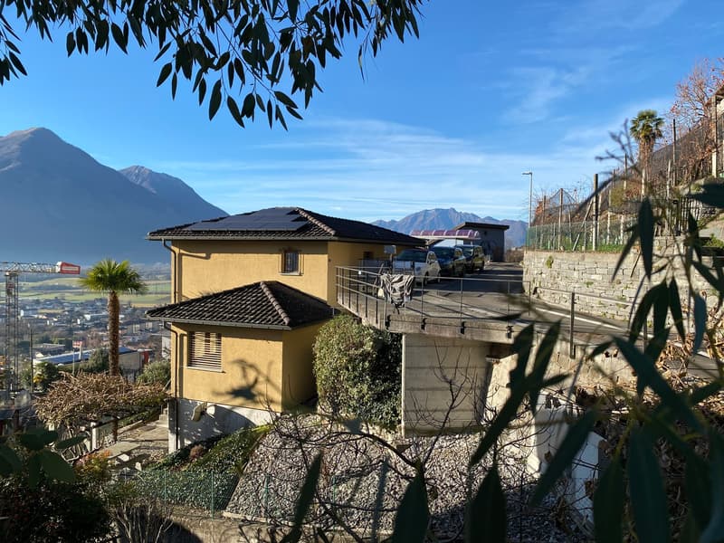 2 story house, solar panels on the roof, bridge with cars, surrounded by nature