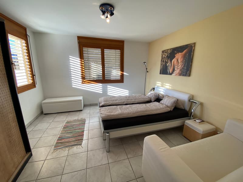 Two single beds, wooden bench, rug, ceiling lamp, picture, lamp