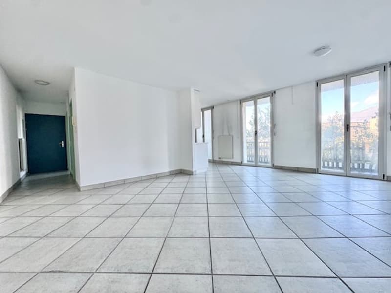 Tiled floor, white walls, large glass windows, balcony, open door, no furniture