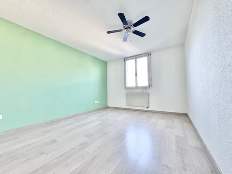 room, wooden floor, green wall, white wall, window, ceiling fan, heater