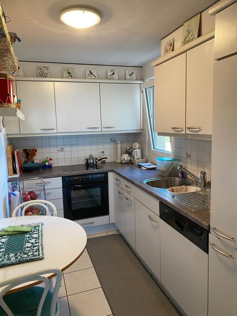 modern kitchen with white cabinetry, granite countertop, integrated dishwasher, electric oven, and washing machine