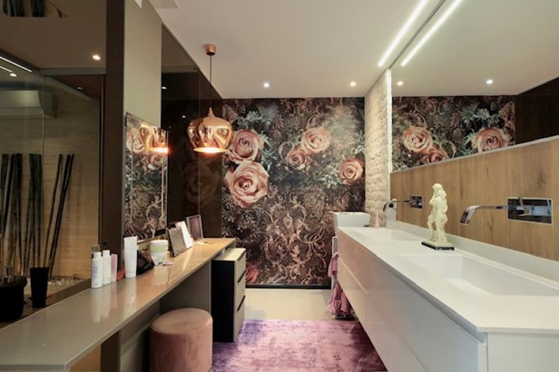 white vanity with double sink, mirror, flower wall paper, vanity lights, stool, carpet, floor lamp