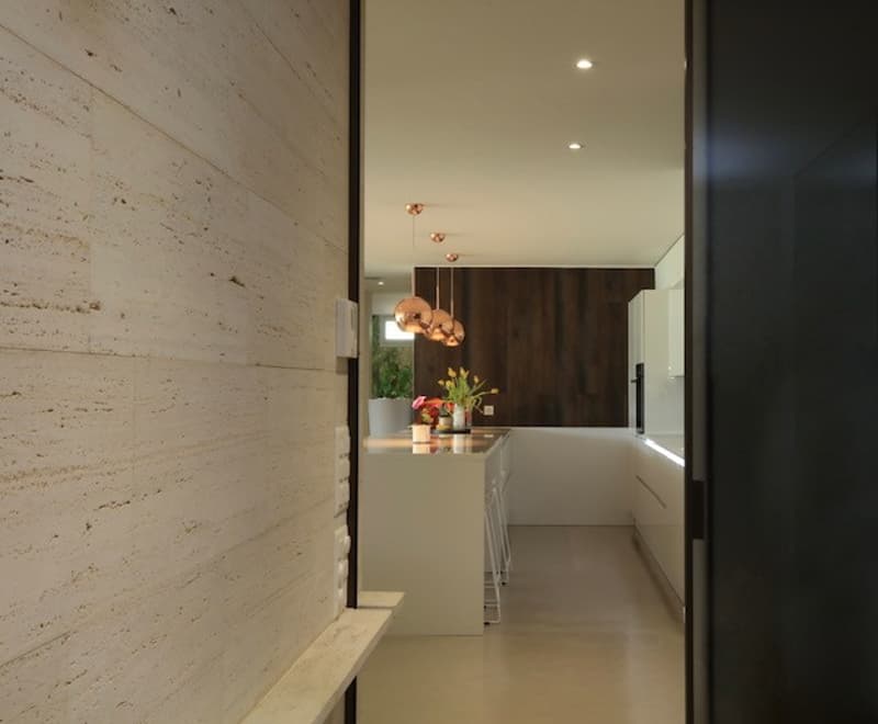 Modern kitchen, white countertop, wooden cabinets, flowers, hanging lamps, neutral tones
