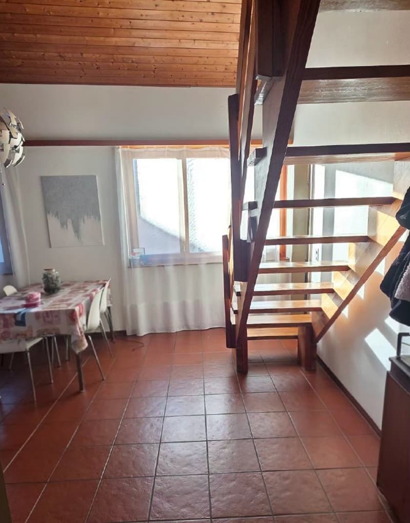 dining room with table and chairs, wooden staircase, window with curtains, wooden ceiling, painting on the wall