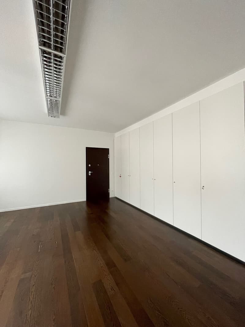empty room, white walls, brown hardwood floor, door, white wardrobe