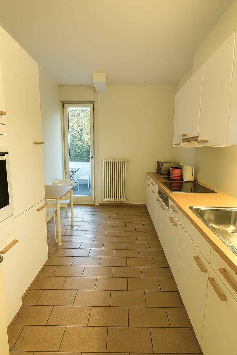 modern open-plan kitchen with white appliances and tiled flooring