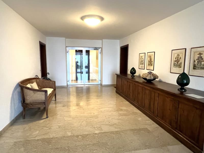 marble floor, white walls, wooden bench, glass door, framed pictures, decorative items
