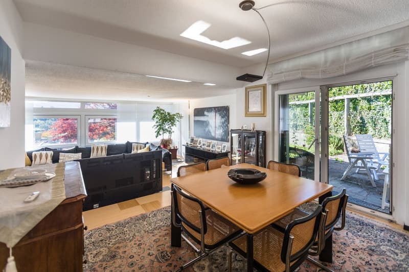 dining table, wooden chairs, carpet, couch, windows, sliding glass doors to balcony