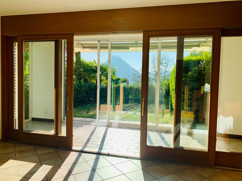Sliding doors leading to balcony, tiled floor, distant mountain view