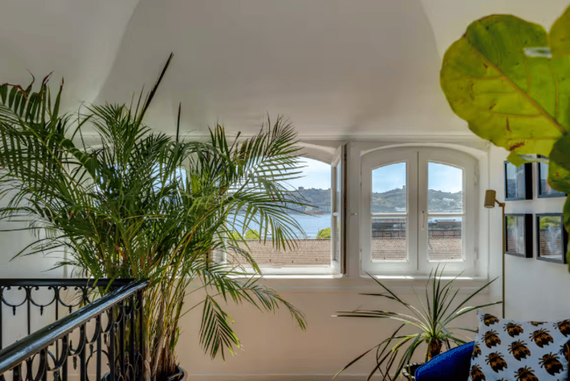 arch window, coastal view, plants, couch, wall pictures