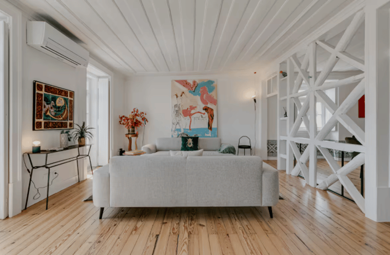 Gray sofa, white walls, wooden floor, decorative items, artwork
