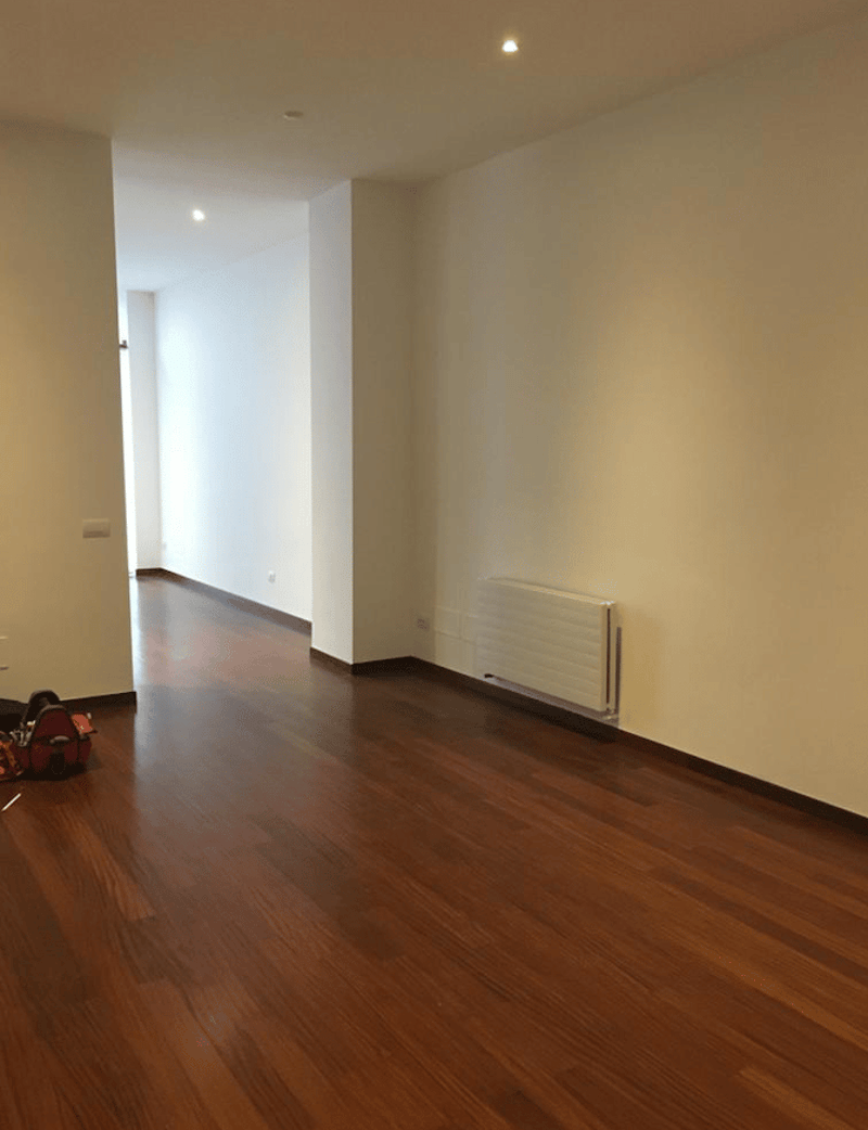 empty room, wooden floor, white walls, ceiling lights, white radiator