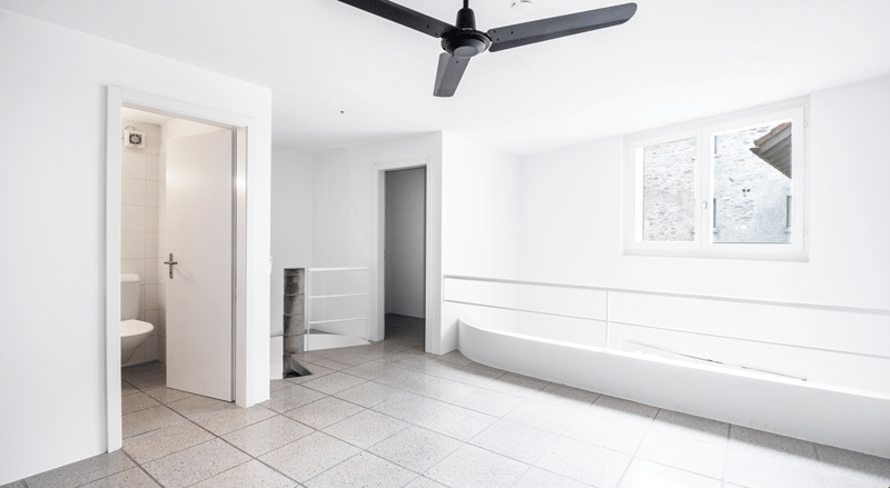 Modern white bathroom with bathtub, toilet, open room with windows, fan, floor