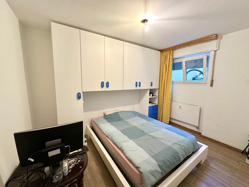 bed, white wardrobe, radiator, monitor, desk, blue curtains