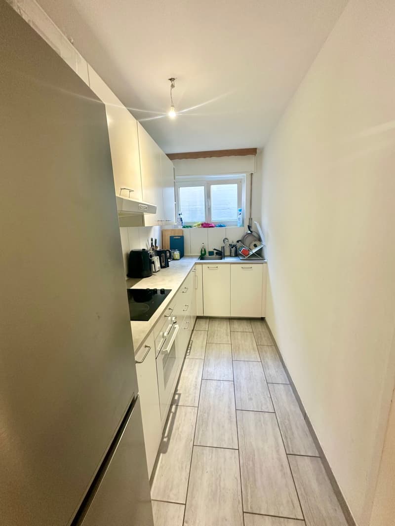 white cabinets, tiled floor, modern appliances, compact layout