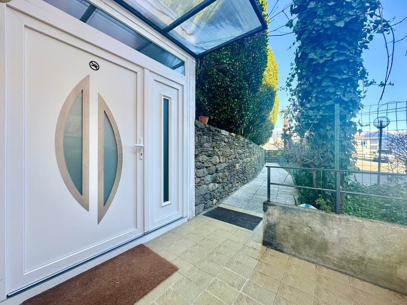 tiled entrance walkway, stone wall, wooden double doors, pathway