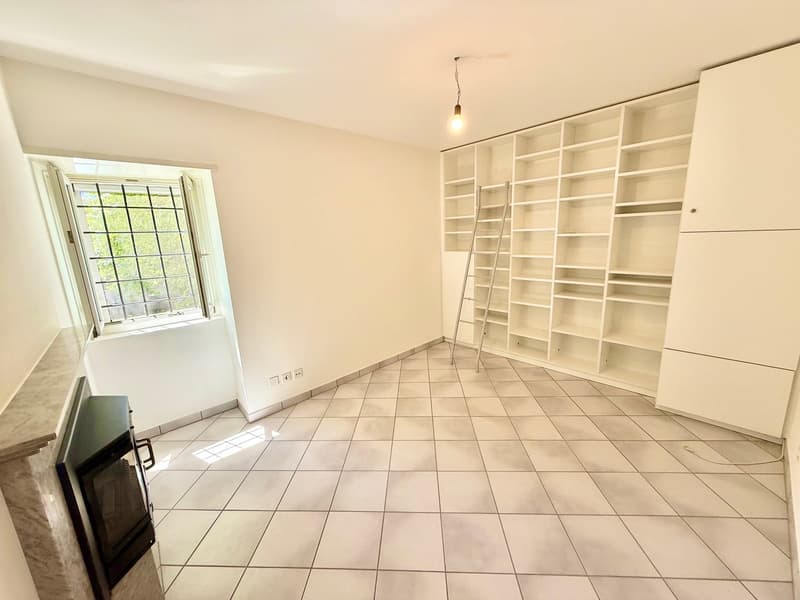 Empty room, white walls, white tiled floor, fireplace, large window, built-in shelves, ladder, power outlets