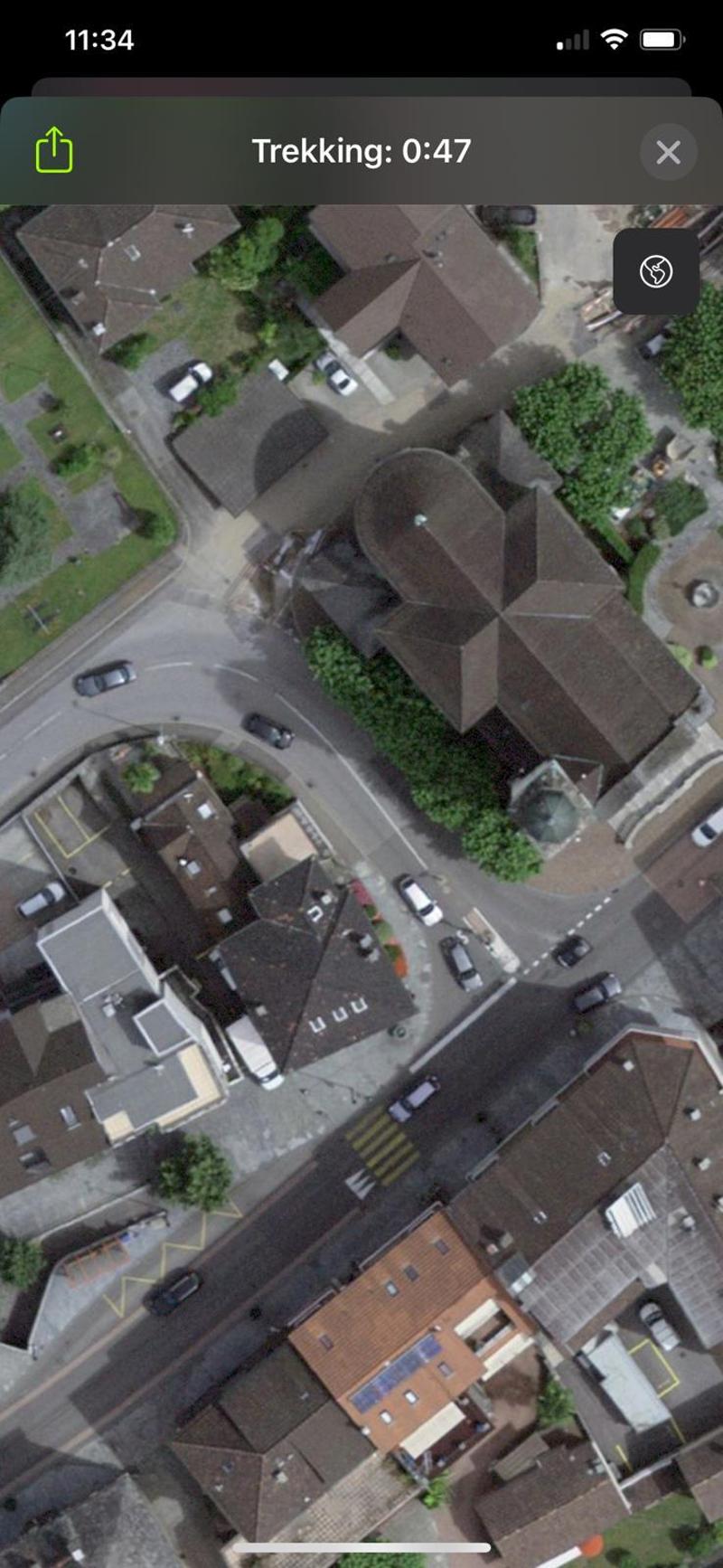 Large building in a residential area, solar panels on the roof, multiple parking spaces