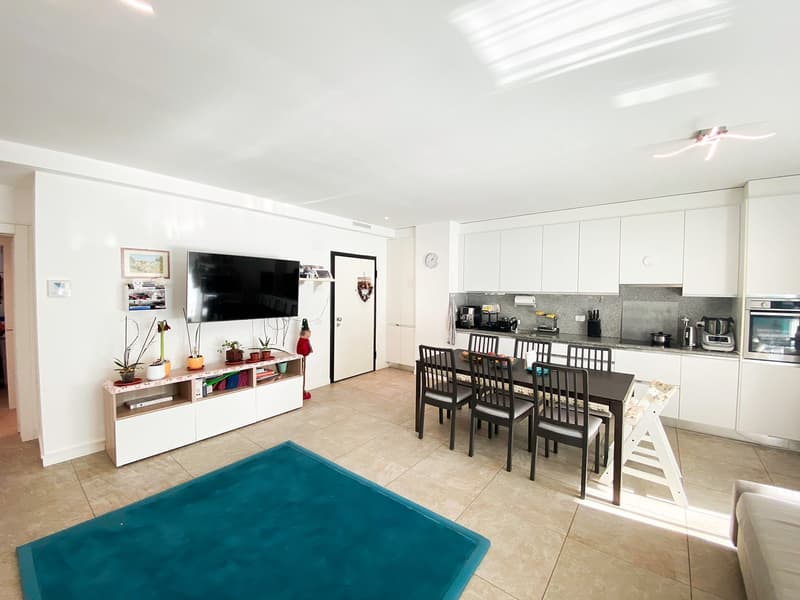 modern design, white cabinets, light colored floor, dining table and chairs, white entertainment center, flatscreen TV, couch