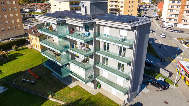 Apartment building, 4 stories, solar panels, balconies, fenced garden, playground