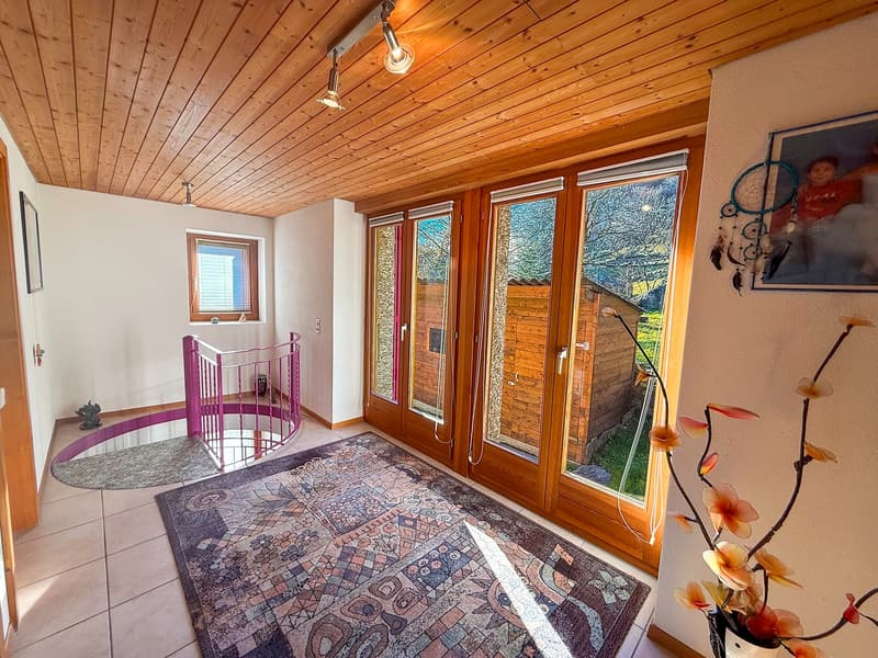 wooden ceiling, carpet, sliding glass doors, spiral staircase, tiled floor, picture on the wall, flower arrangement