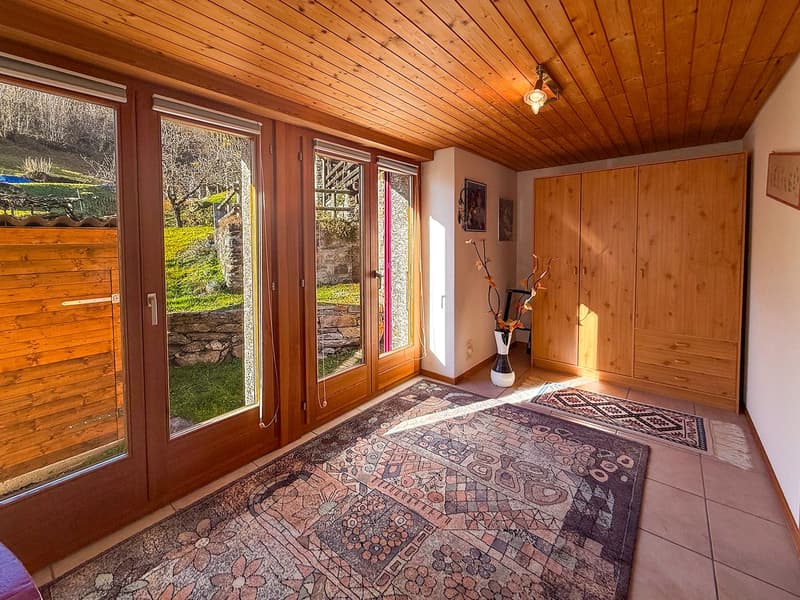 wooden doors, large windows, floor lamps, rugs, wooden cabinets, vase with flowers