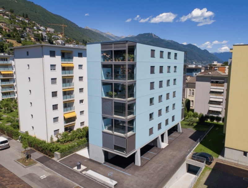 Blue and white building, 5 floors, several balconies visible