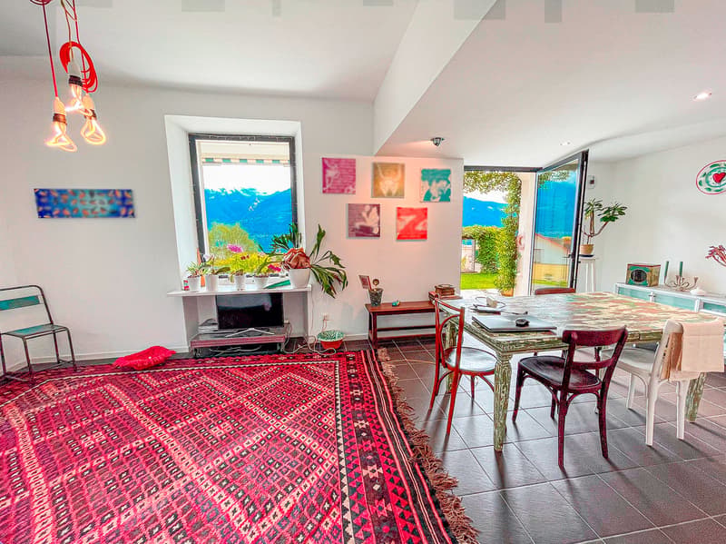 red rug, white tile, red chairs, glass table, TV on stand, open window