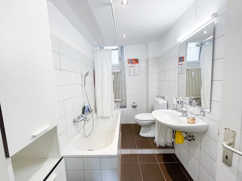 white tiles, white bathtub, white toilet, white sink, silver faucet, radiator, shower curtain