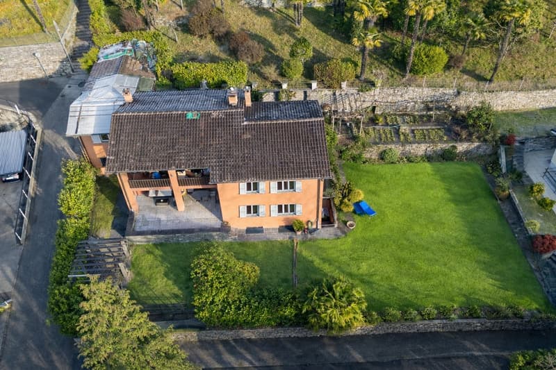 detached house, large landscaped garden, stone retaining walls, outdoor seating area, paved driveway
