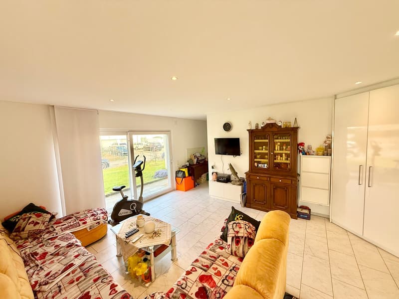 2 sofas, central table, TV, window, cabinet, door, clock, fitness bike