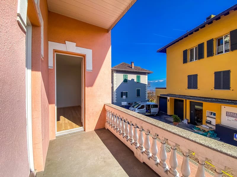 Wooden flooring, pink wall, balcony, railings, view of mountains