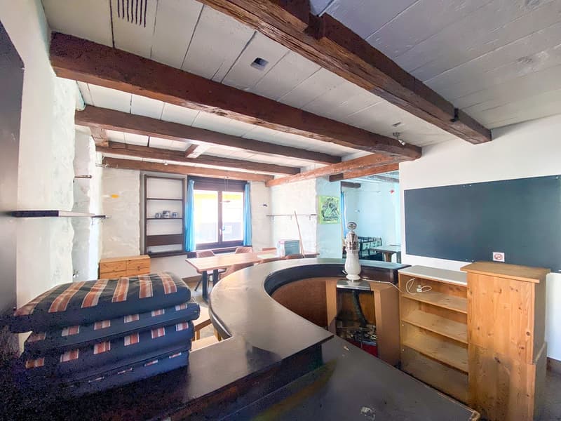 open room with high ceiling, desk, shelves, window, blackboard, counter
