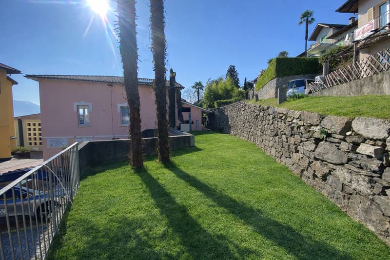 lawn, stone wall, cars parked in front of the fence