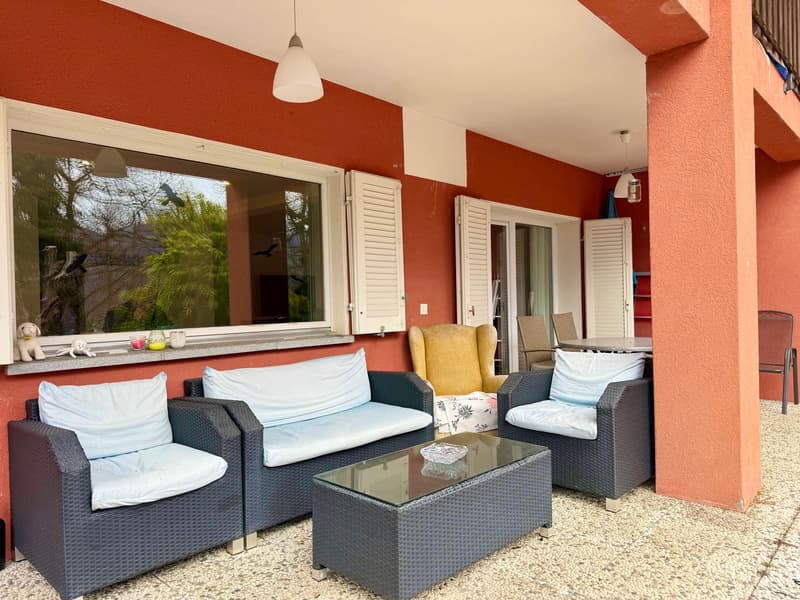 Terrace with sitting area, coffee table, and chairs; glass window overlooking trees