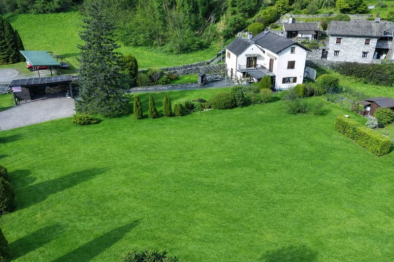 house in the country, surrounded by greenery, stone walls, garage, parking