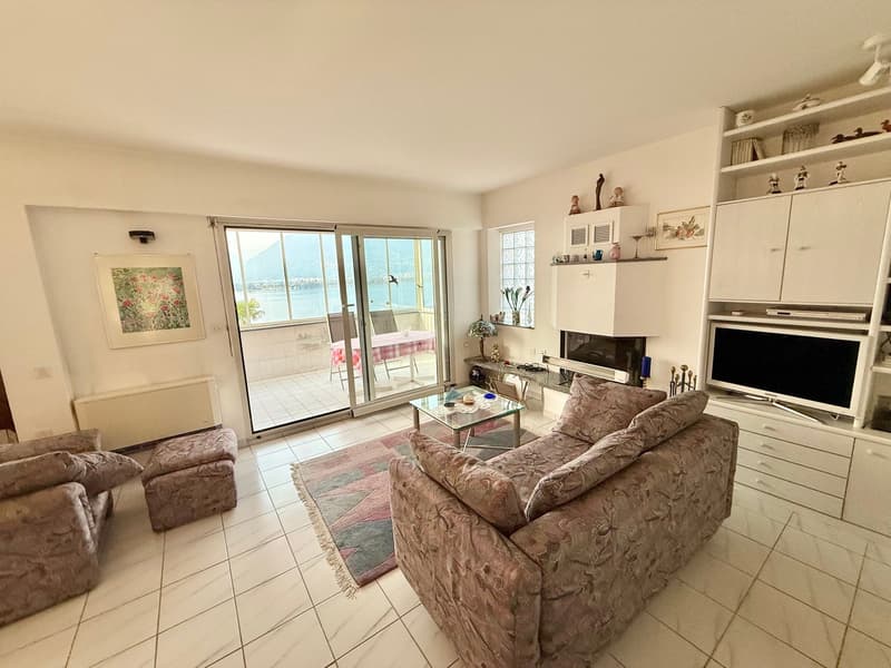 large windows, sliding glass doors, balcony, couch, coffee table, TV, fireplace
