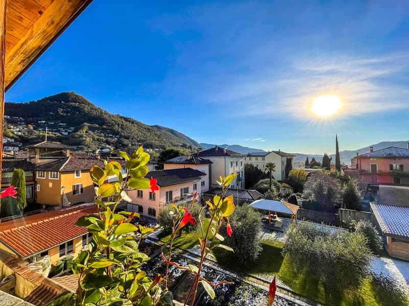 Aerial view of a town with houses, mountains, and a clear blue sky