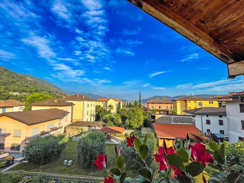 View of a town with houses, mountains, and a clear blue sky